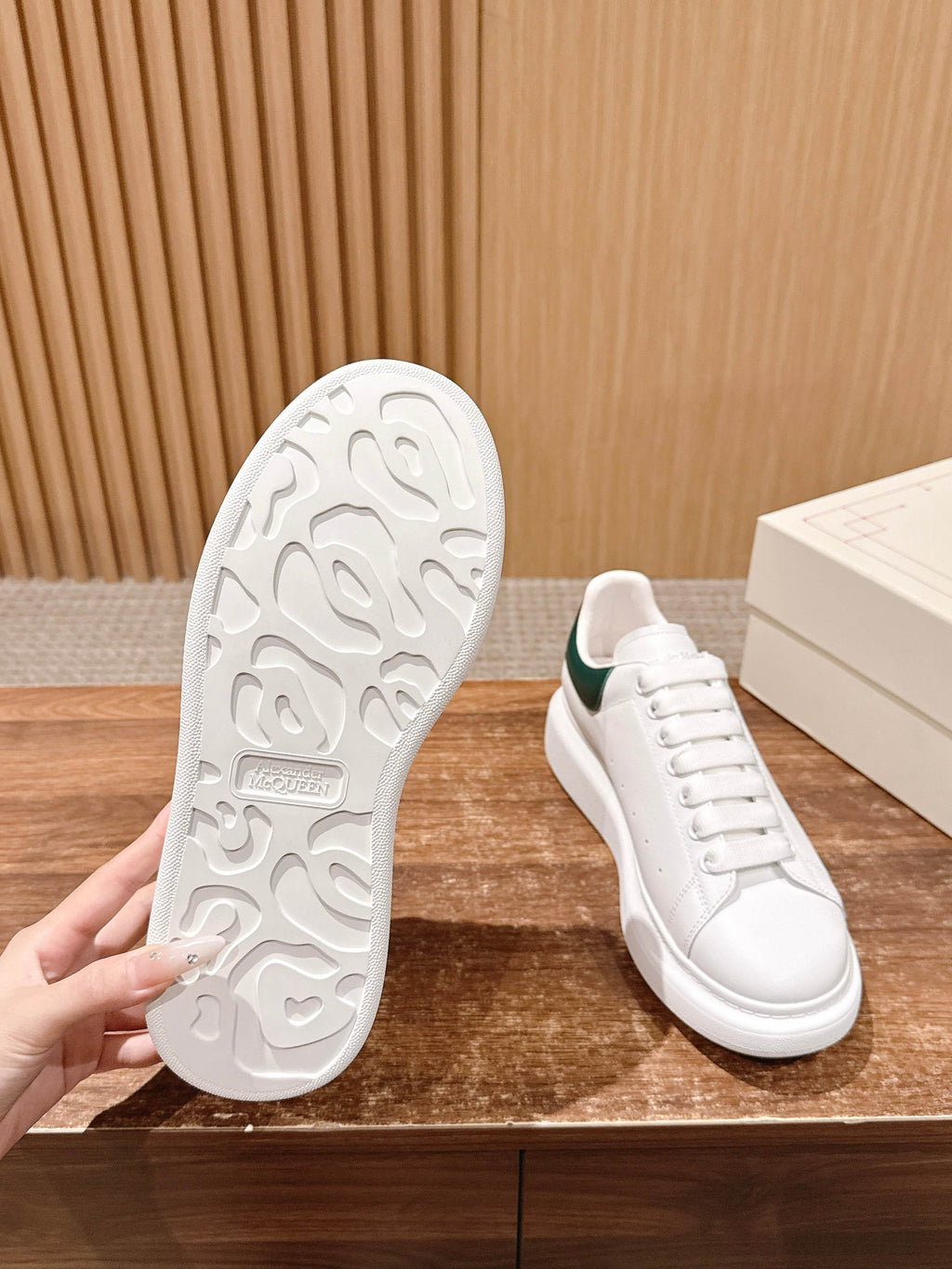 White sneaker outsole tread with green-collared upper in view