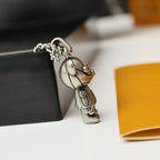 Silver bear figurine charm pendant on a chain near a black display box