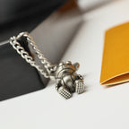 Silver bear charm pendant with chain links resting on a black display box