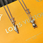 Silver chain necklace with LV charms and a dangling bear figure pendant