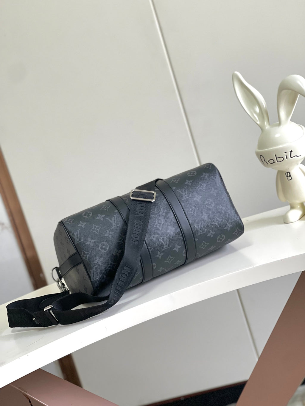 Louis Vuitton duffel bag side view in dark navy monogram canvas with crossbody strap