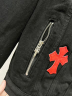 Louis Vuitton denim jacket close-up: silver zipper and red cross patch on dark fabric