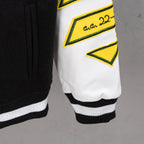 Black-and-white varsity jacket cuffs with ribbed hem and yellow logo trim