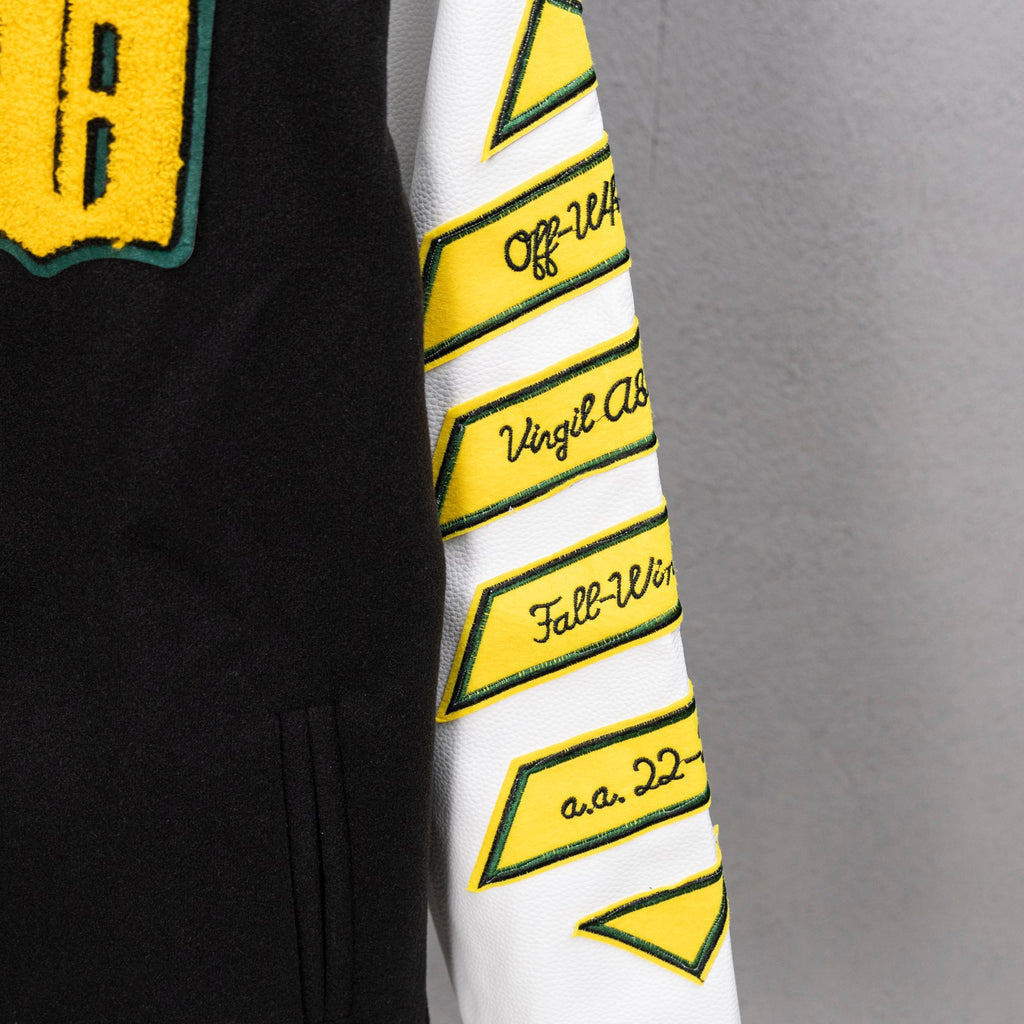 White sleeve panel with yellow geometric logo trim and black stripe accents