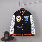 Black varsity jacket with orange trim, white sleeves, snap buttons, and front logo patches.