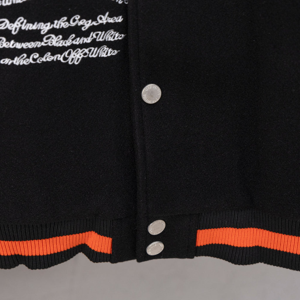 Black varsity jacket hem with orange ribbed band and snap buttons on placket.