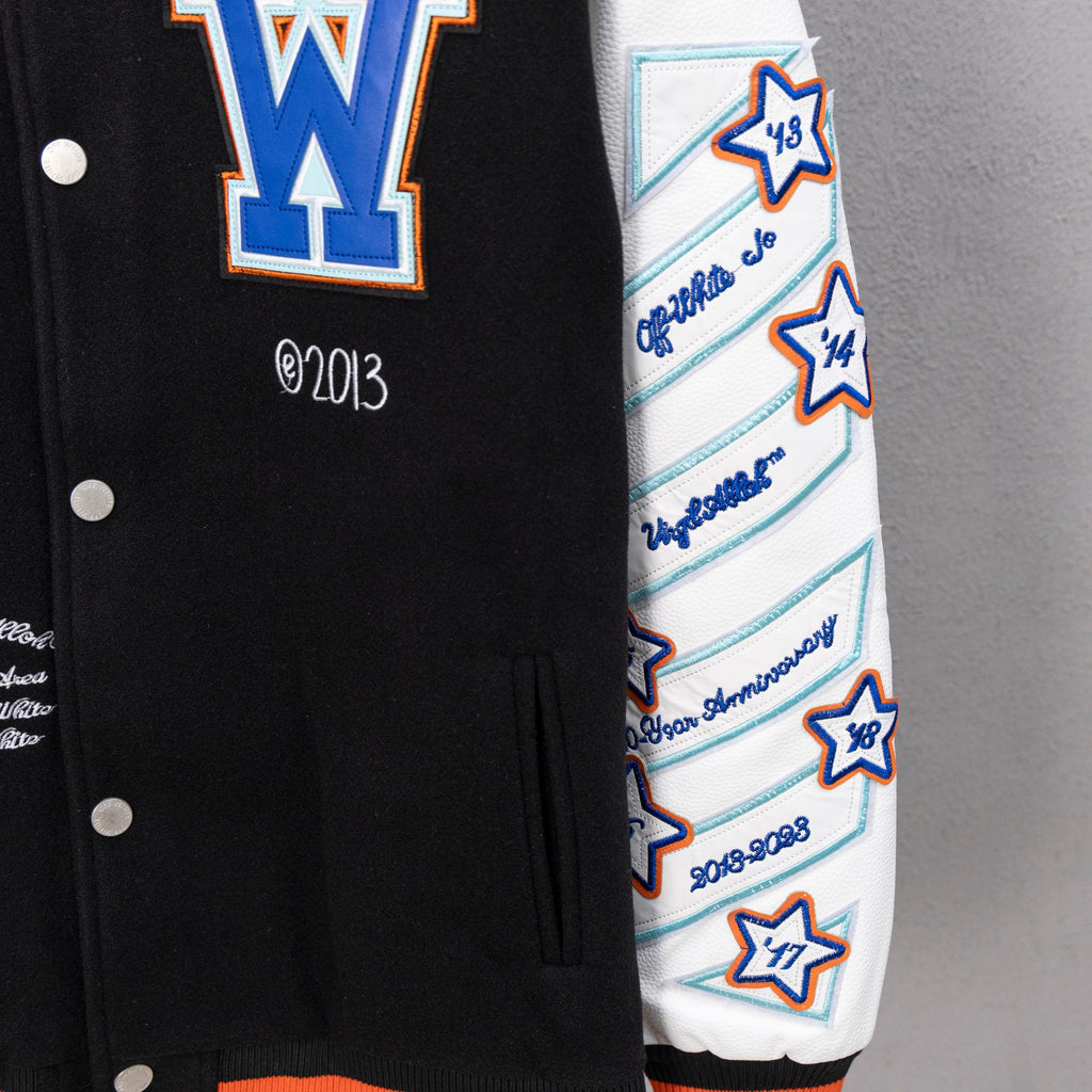 Varsity jacket sleeve with white base, blue stripes, star patches, and knit cuff.
