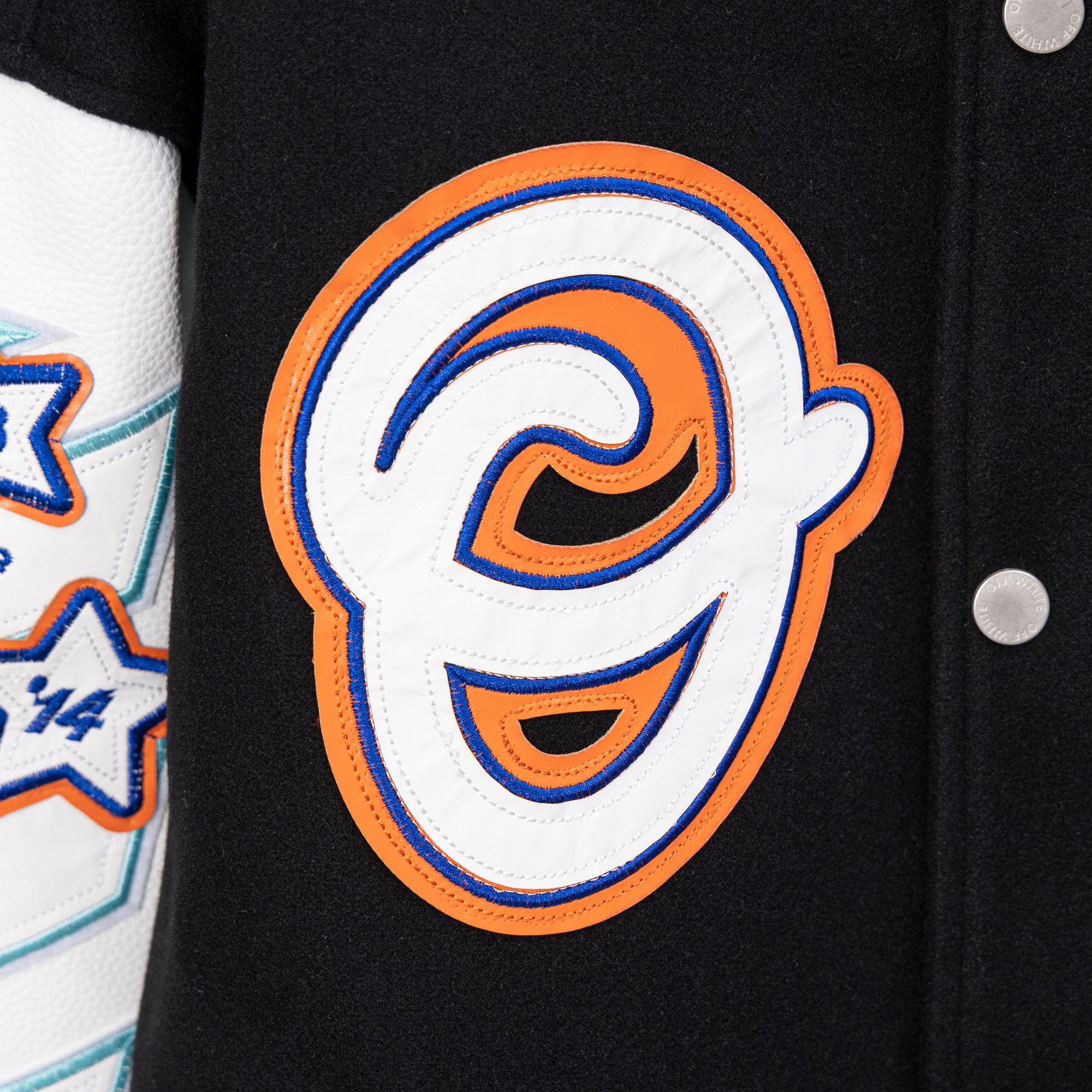 Black varsity jacket with large embroidered orange-and-blue O logo patch and white border.