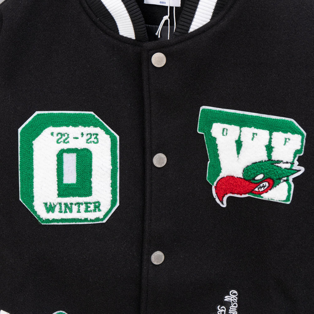 Black varsity jacket with snap front and green winter-themed patch badges