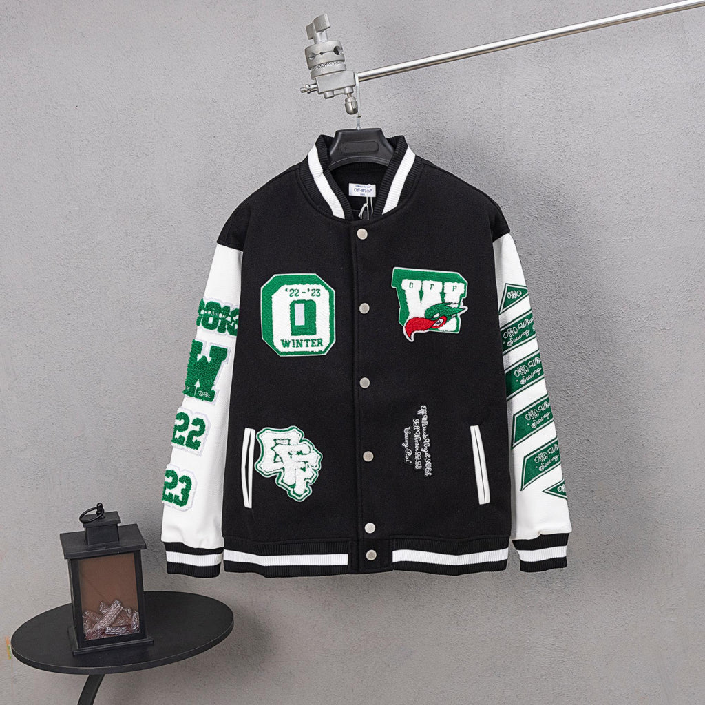 Black varsity jacket with white stripes, snap buttons, and green graphic patches