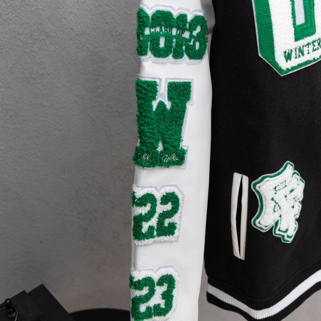 White sleeve panel with green number patches and ribbed striped cuff