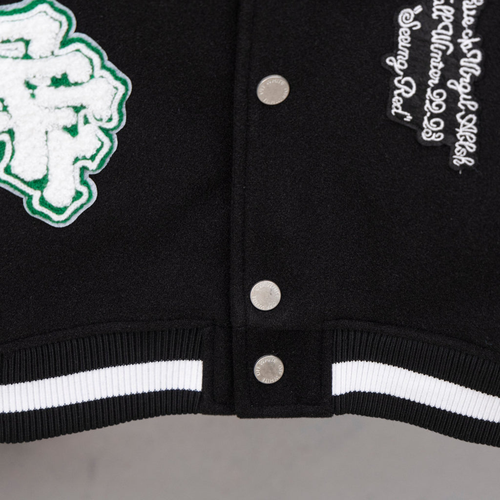 Black varsity jacket hem with ribbed striped cuffs and silver snap buttons