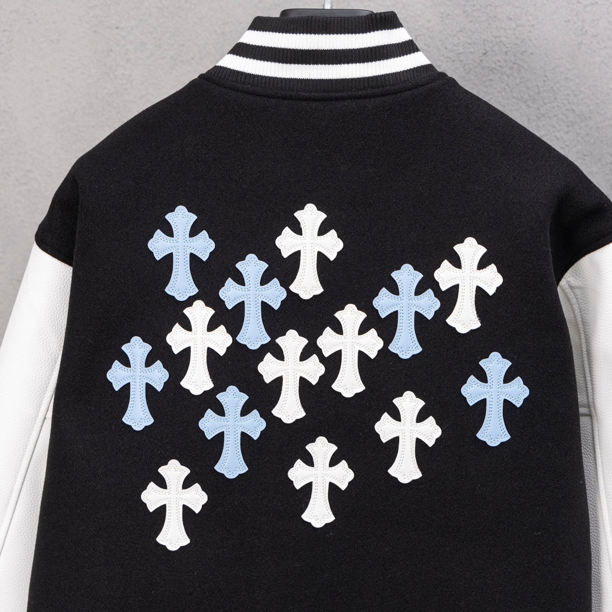 Black jacket back with large cross graphic in white and light blue