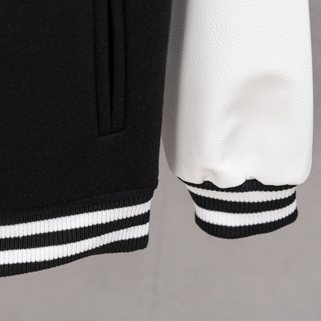 Black jacket hem with striped ribbing and white contrast sleeve