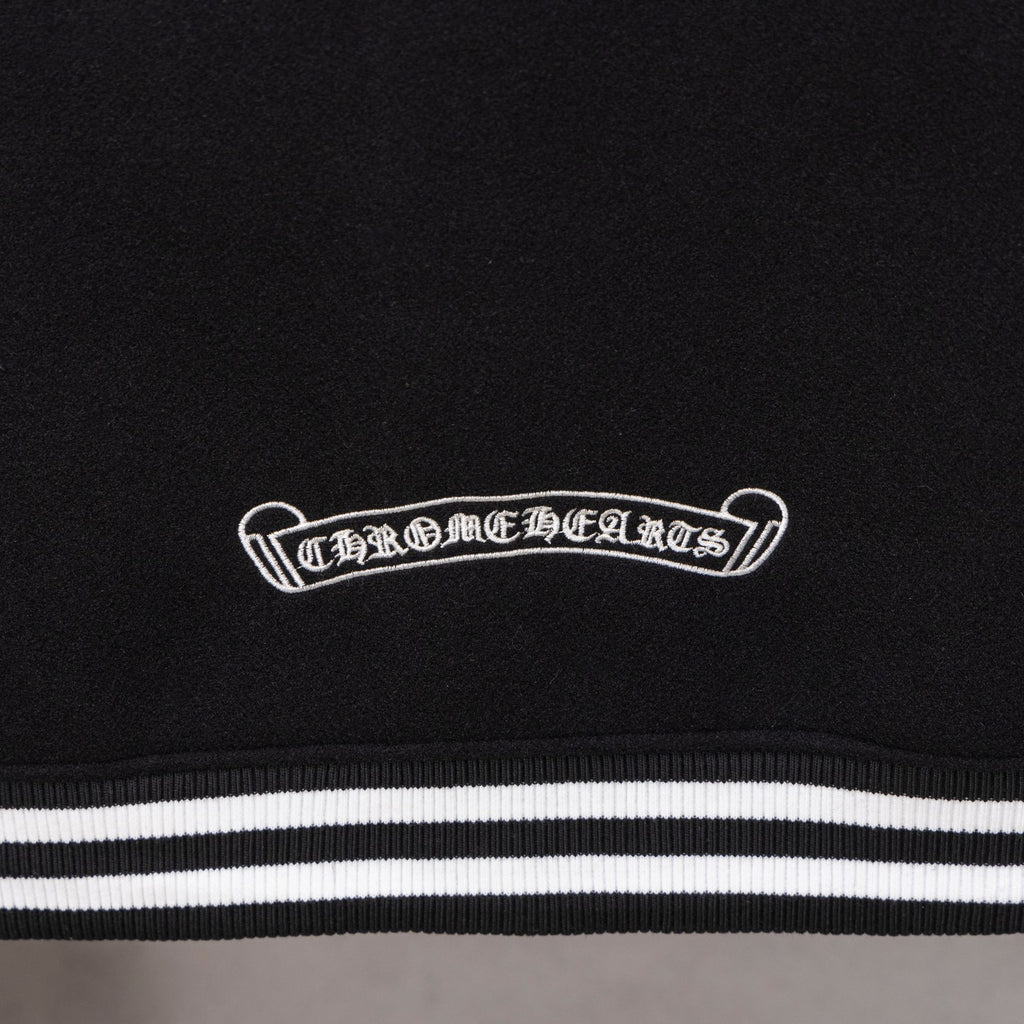 Black jacket chest patch above striped waistband-style trim