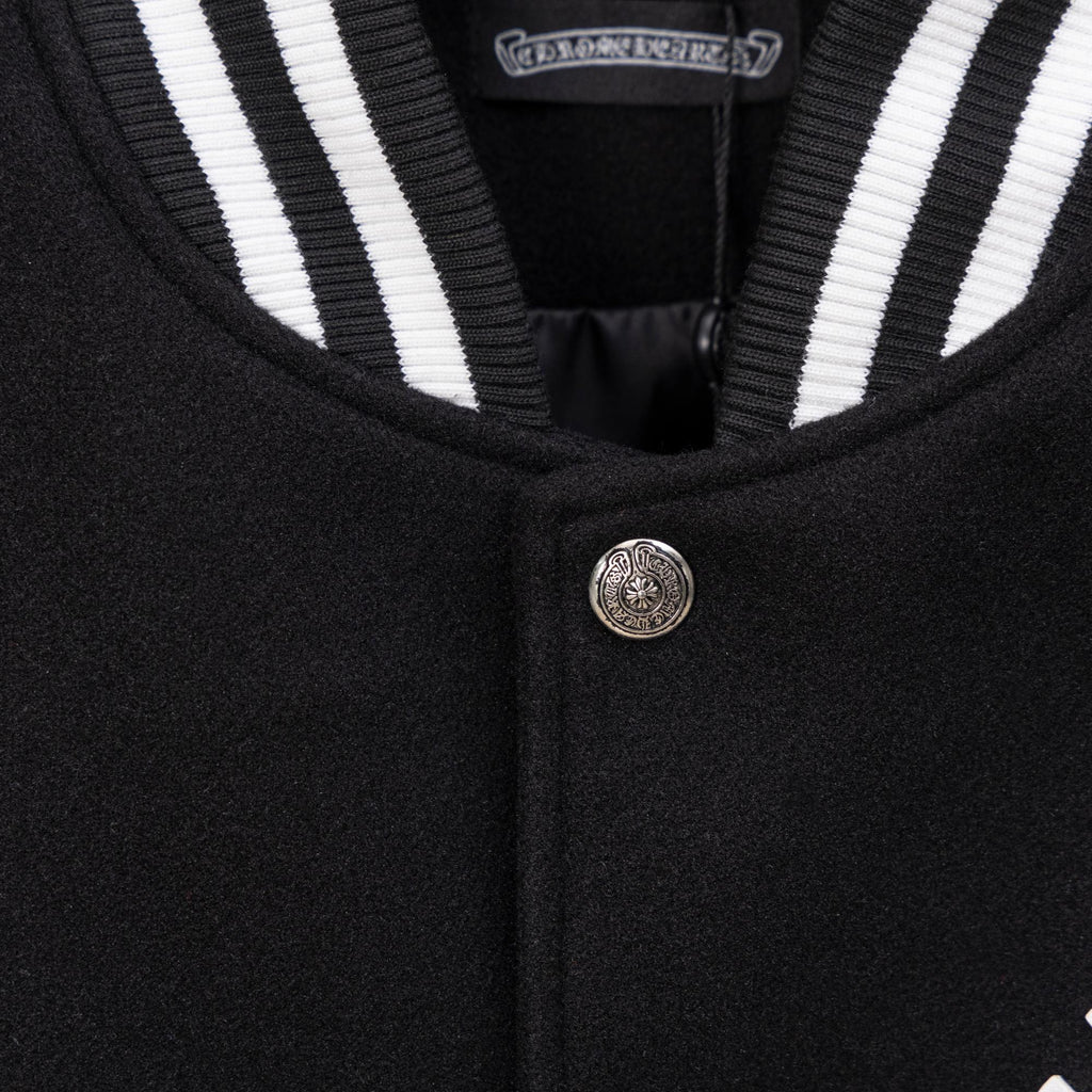 Black jacket neckline with striped ribbed trim and metal button closure