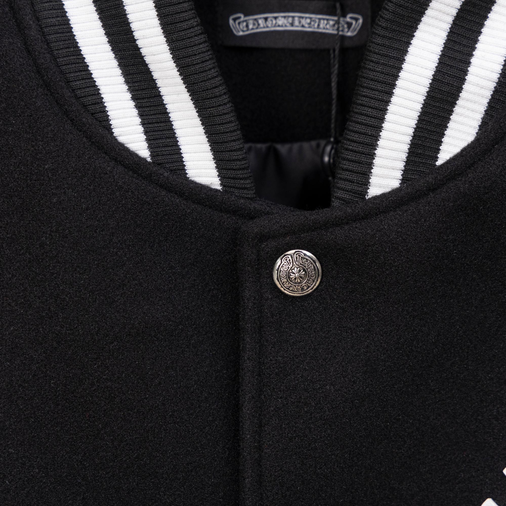 Black jacket neckline with striped ribbed trim and metal button closure