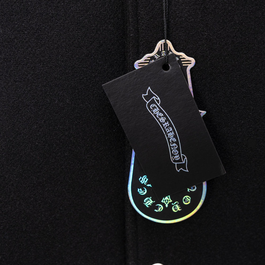 Black clothing tag attached to dark knit jacket fabric