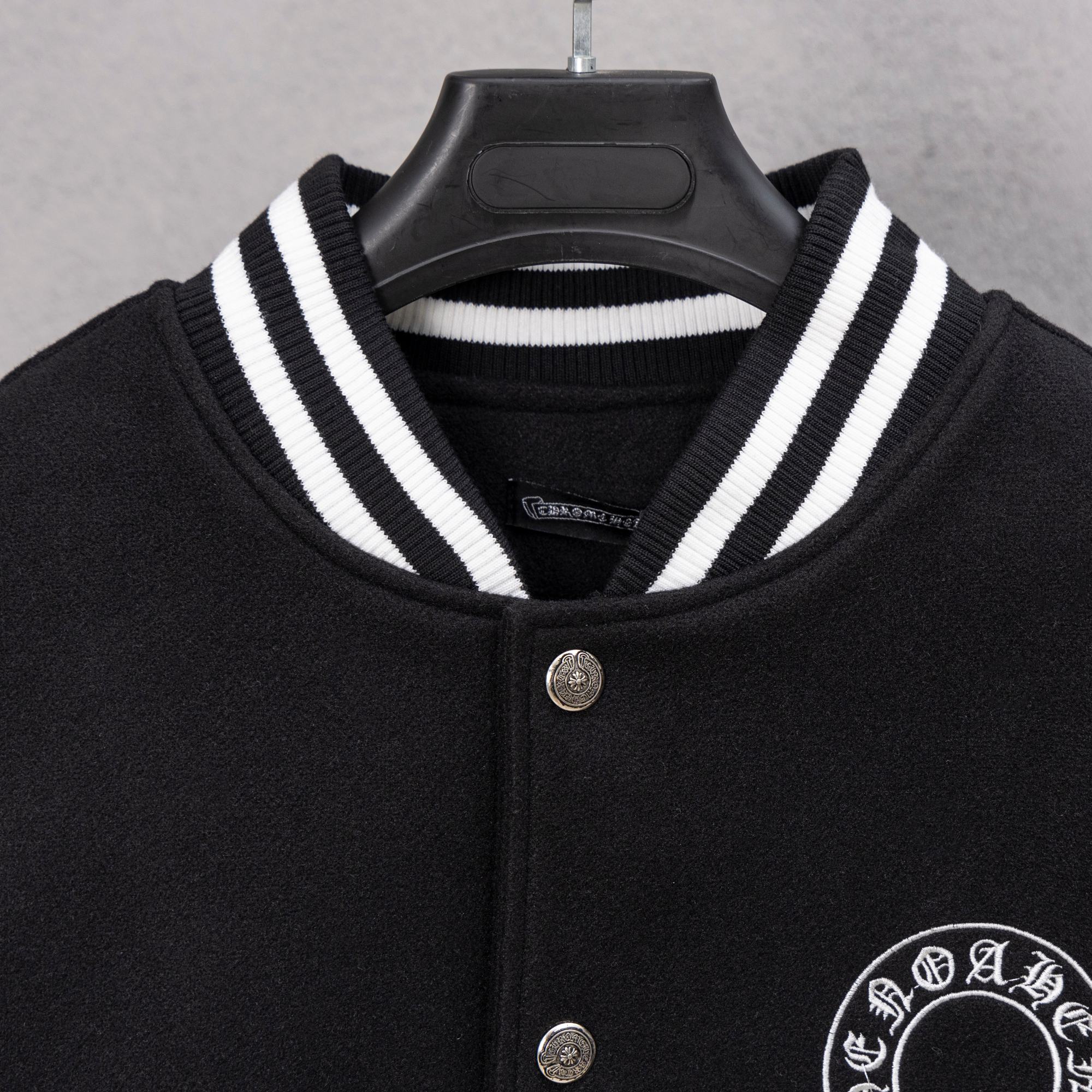 Black varsity jacket with striped knit collar and silver snap front buttons