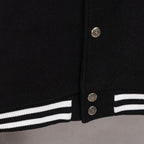 Black snap-front varsity jacket with silver buttons and striped cuff trim