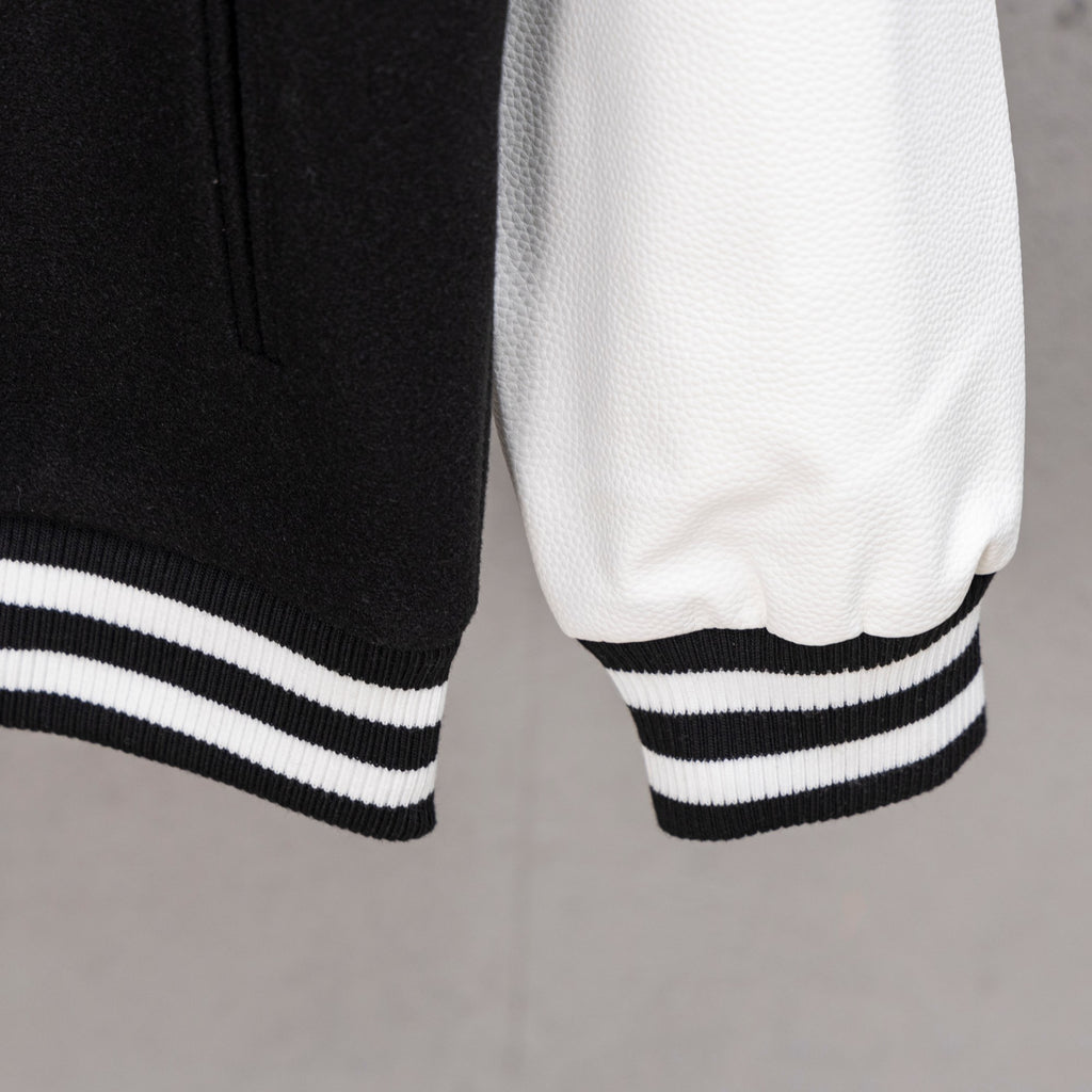 Black and white striped ribbed cuff and hem on varsity jacket sleeve
