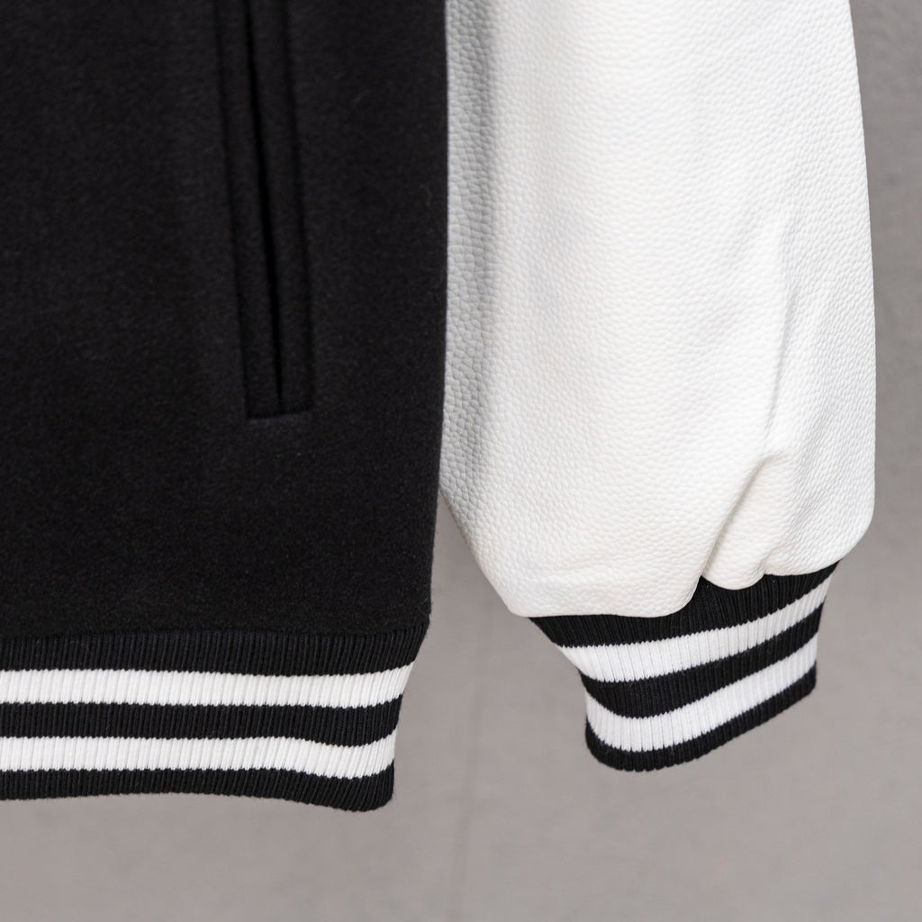 White sleeve with black panel and striped ribbed cuff on varsity jacket