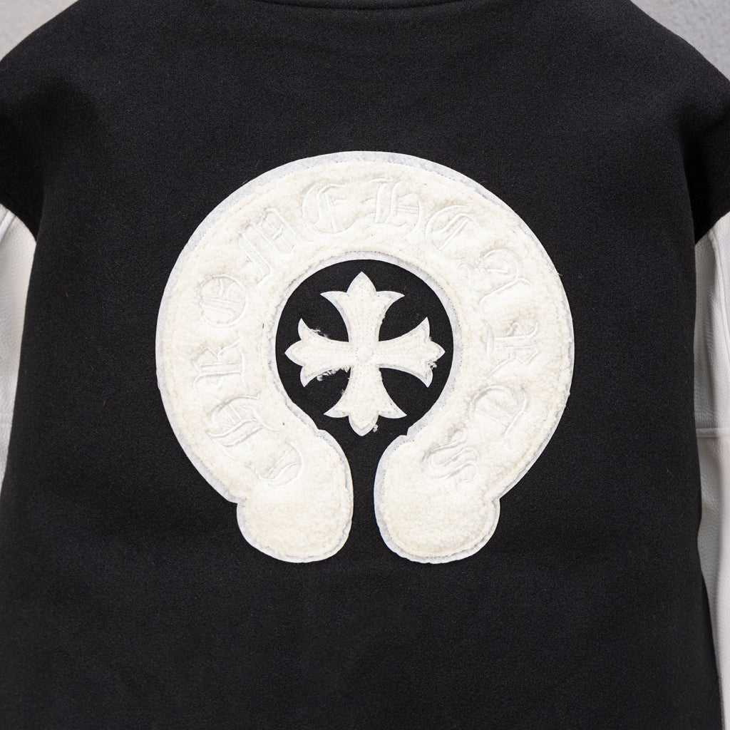 Black varsity jacket back with large white cross-in-curls emblem