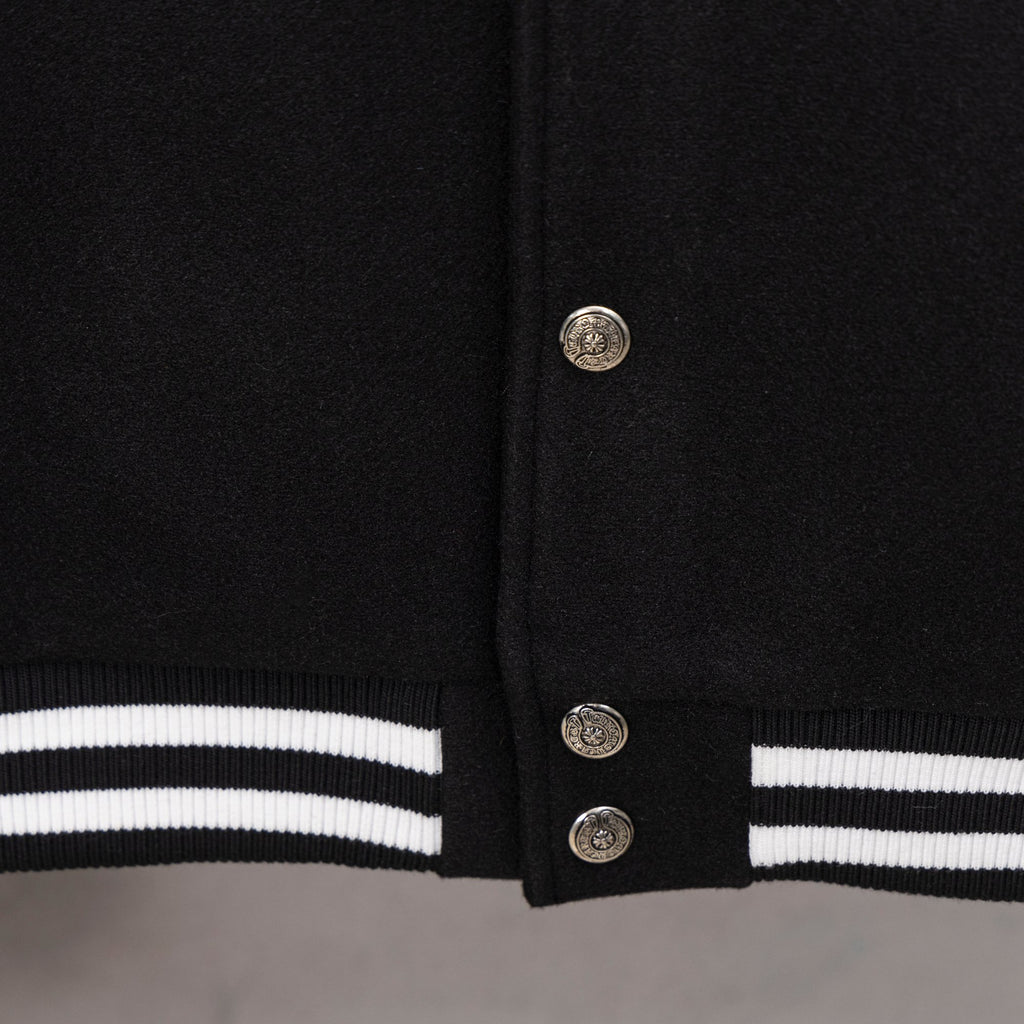 Black varsity jacket hem with striped rib trim and snap button closure