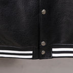 Black leather varsity jacket bottom hem with white striped ribbing and snap buttons