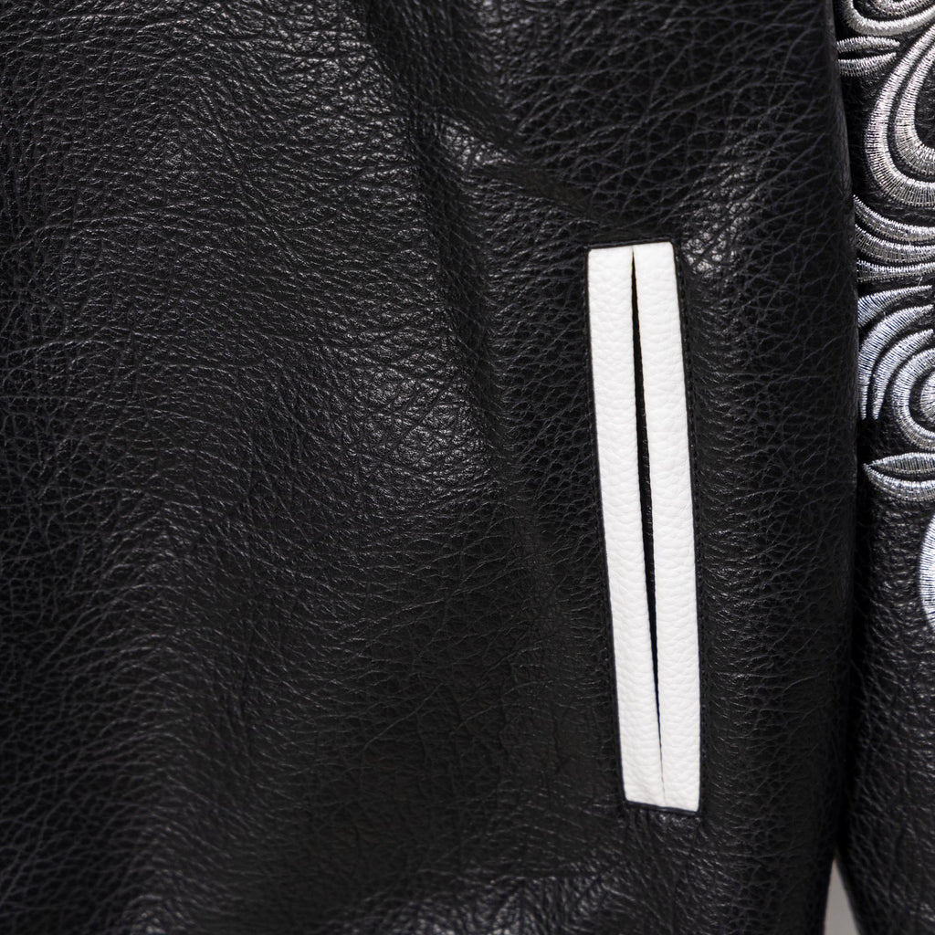 Black leather jacket with rectangular white stripe patch on the sleeve