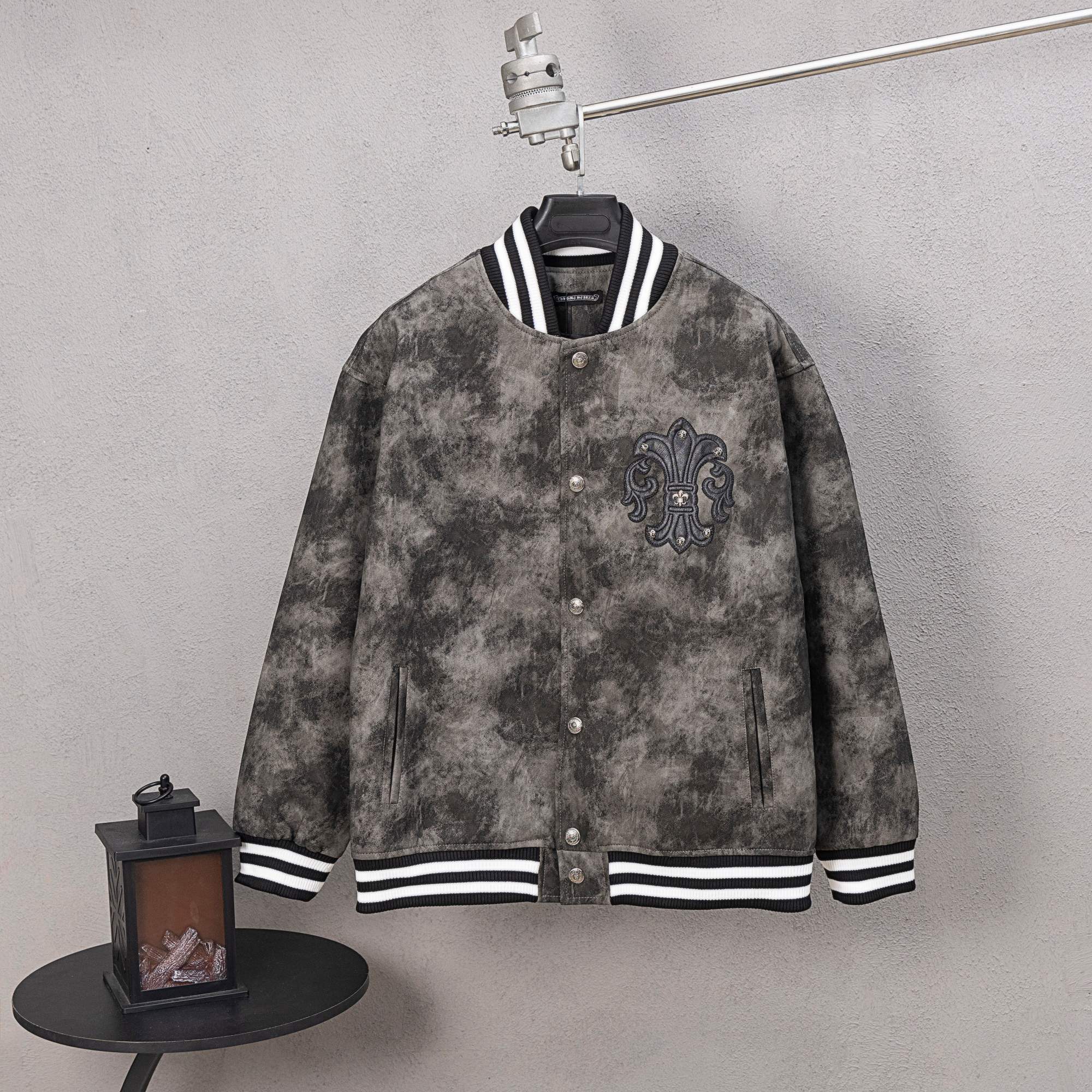 Long-sleeve button varsity jacket with black fleur-de-lis crest, striped cuffs and hem