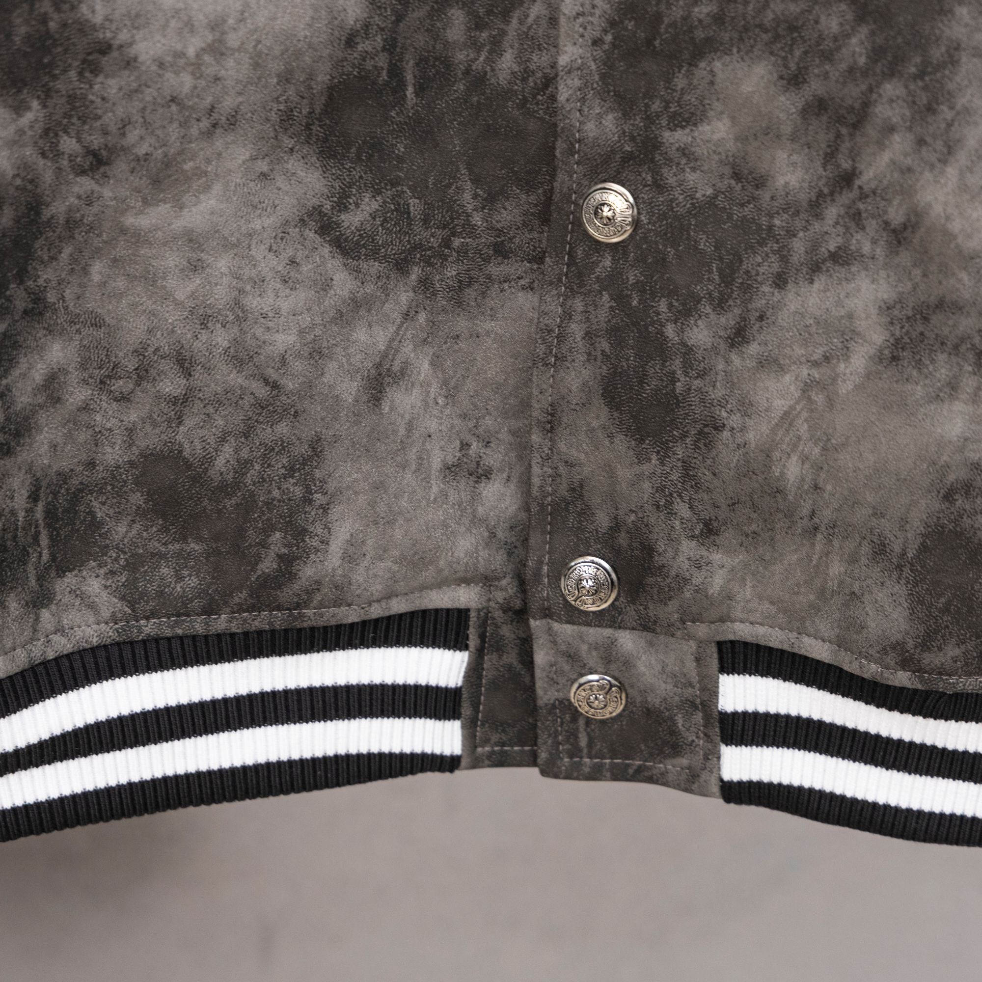 Varsity jacket front button placket with black-and-white striped hem band