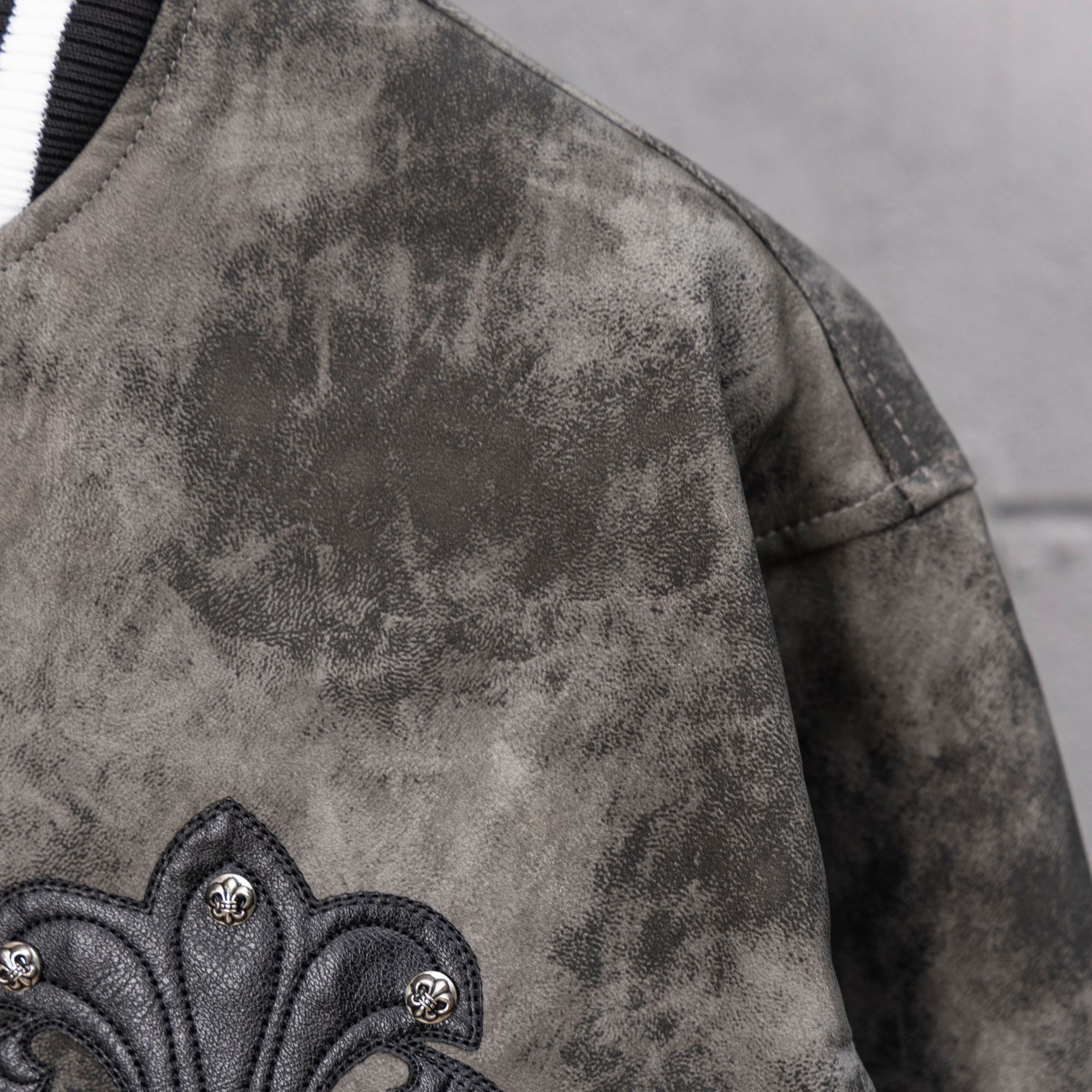 Varsity jacket gray patterned body with black fleur-de-lis applique at sleeve edge