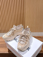 Moncler beige lace-up sneakers with chunky soles, angled view on boxes.