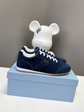 Prada unisex suede sneakers in dark blue with white lace-up, gum sole.