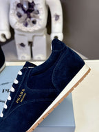 Prada unisex dark blue suede sneakers with white laces and gum sole edge.