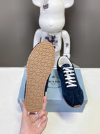 Prada unisex sneaker outsole with geometric tread, dark blue upper on box.