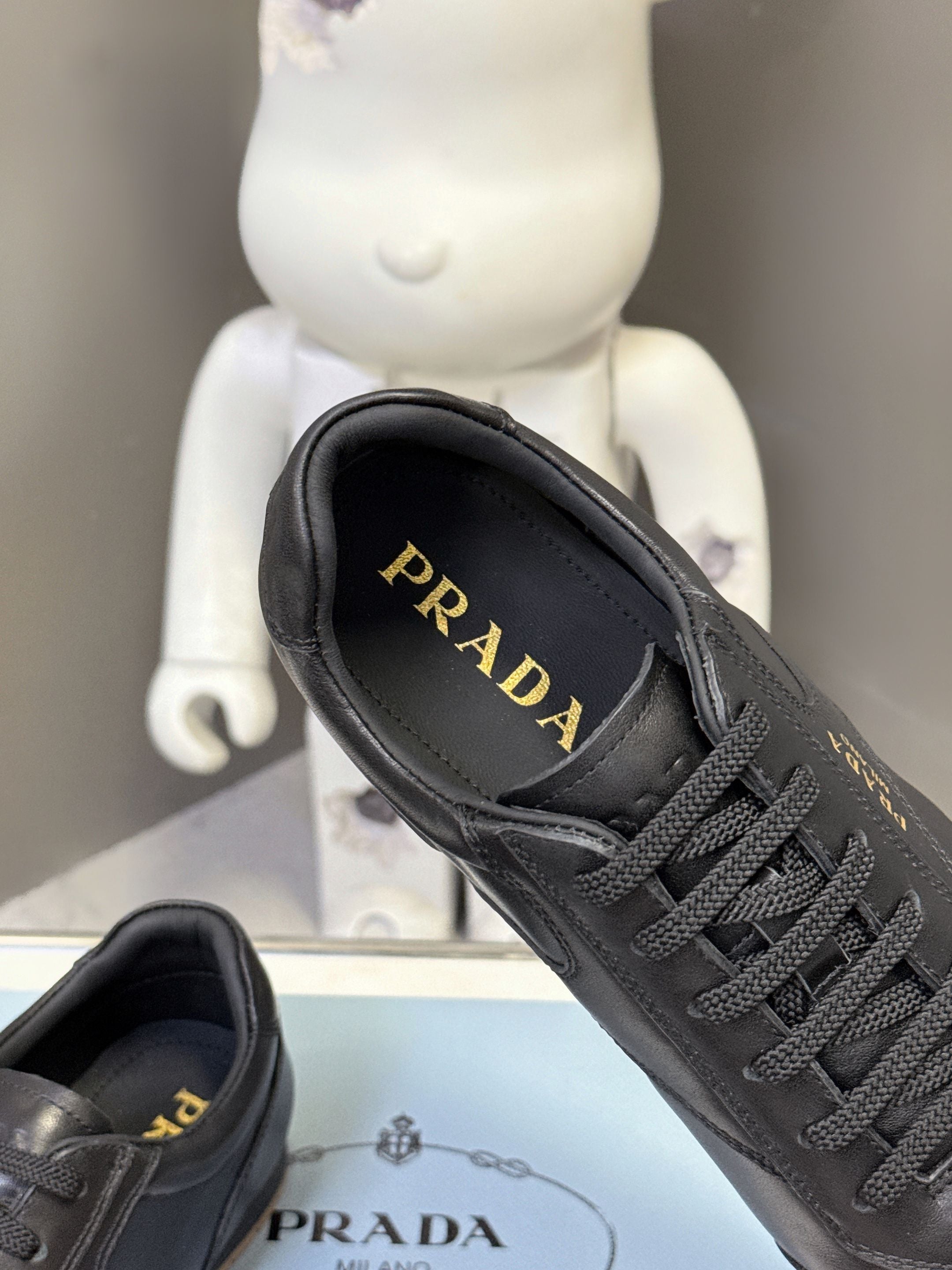 Black leather sneaker with PRADA logo on inner lining, lace-up front