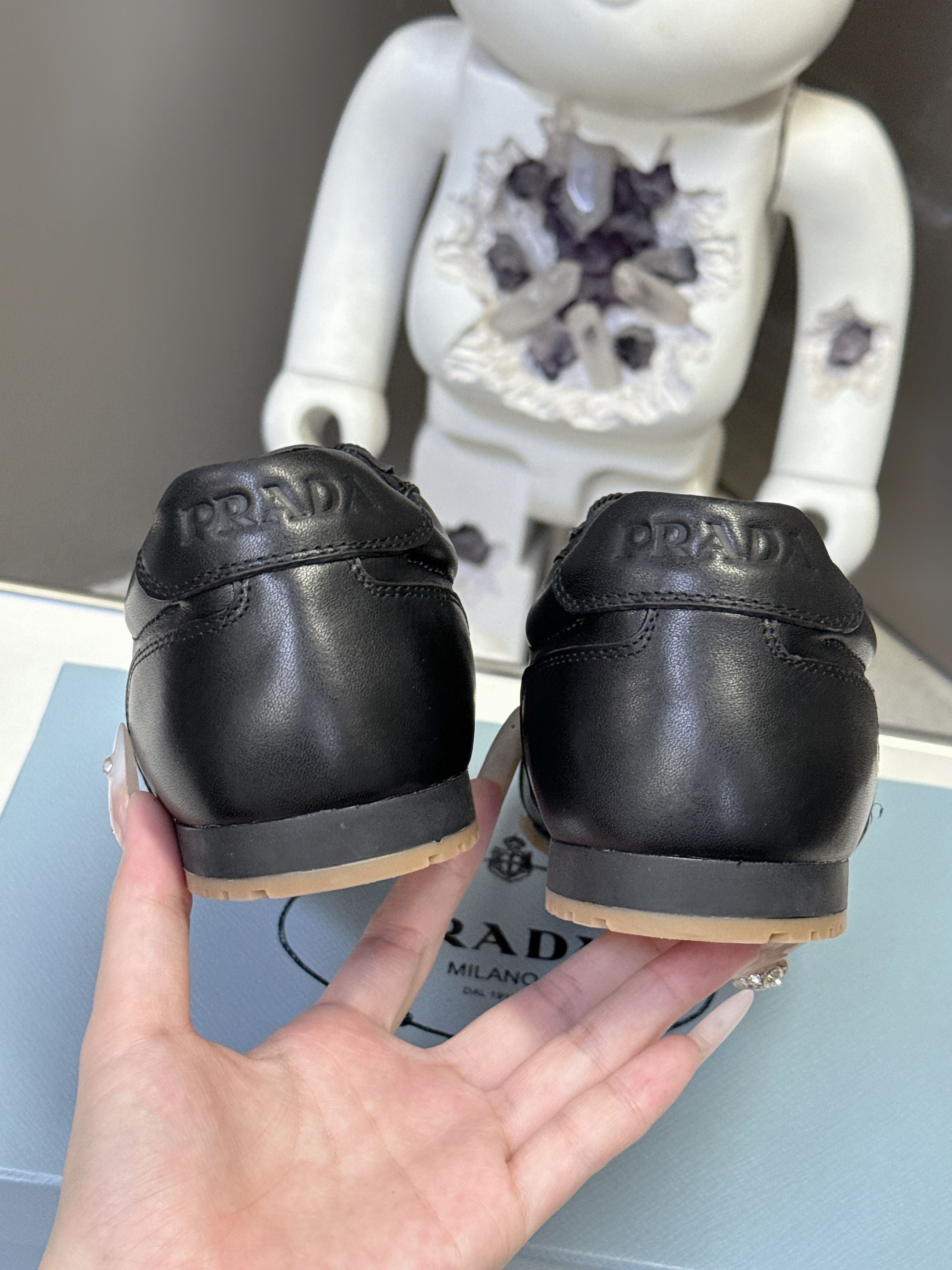 Black leather sneakers, heel PRADA lettering and low gum rubber sole