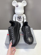 Prada unisex sneakers, black side view with lace-up and embossed logo panel