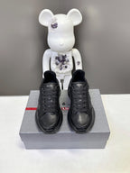 Prada unisex sneakers pair, black low-top lace-up with thick platform sole