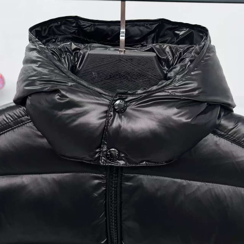 Moncler puffer jacket hooded inner layer close-up, dark color with snap buttons