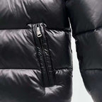 Moncler puffer jacket close-up, dark color, vertical zipper pocket detail