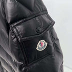 Moncler puffer jacket sleeve/side patch close-up, dark color with circular logo