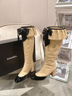 Chanel ladies’ knee-high boots with black bow at top and ruffled cuff