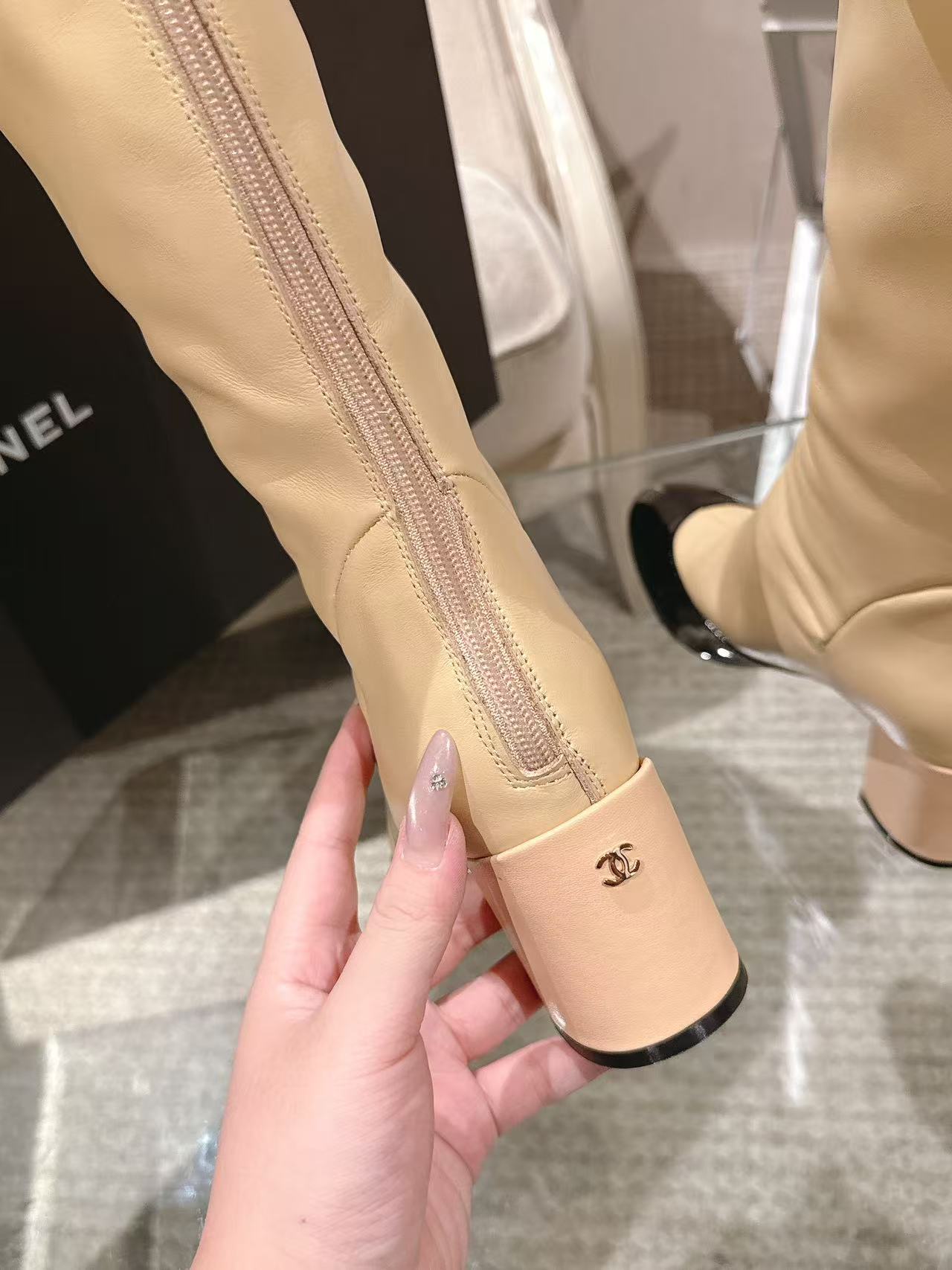 Chanel ladies’ knee-high boot heel detail with signature on cream strap