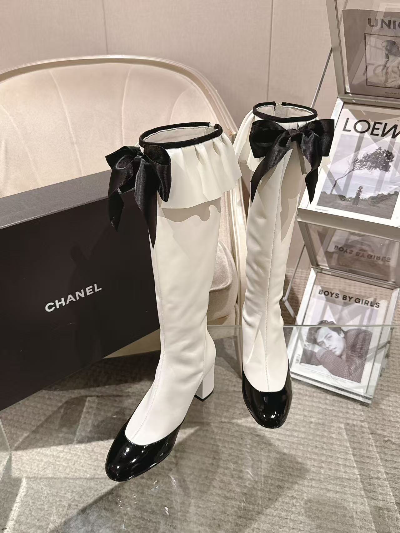 Chanel knee-high heeled boots, white with black ribbon bows and polished toe caps