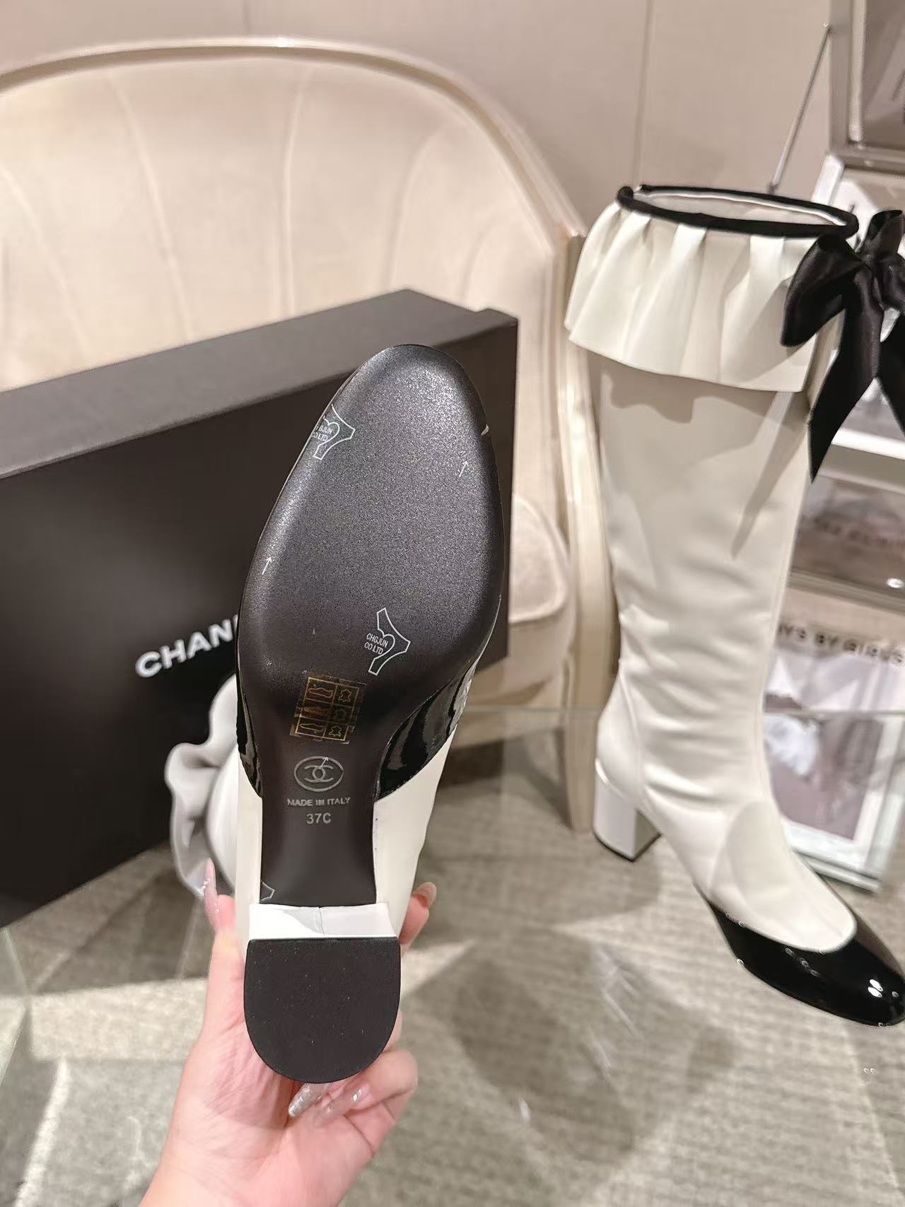 Chanel boot outsole view, dark sole with embossed logo and temperature marking