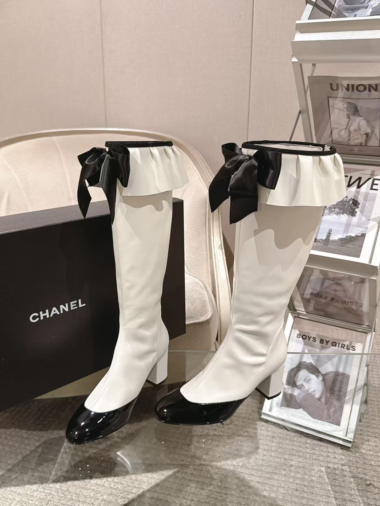 Chanel knee-high boots with black ribbon bows, white uppers and black glossy heels