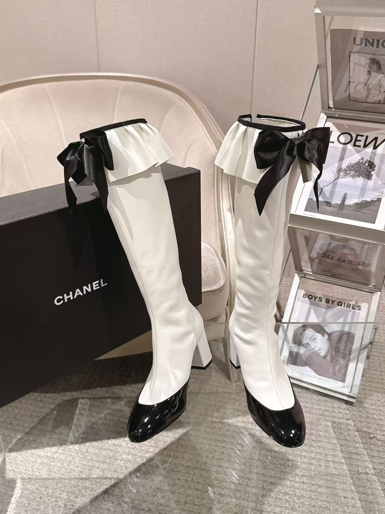 Pair of Chanel high-heel boots, white with black ribbon bows and glossy black toe
